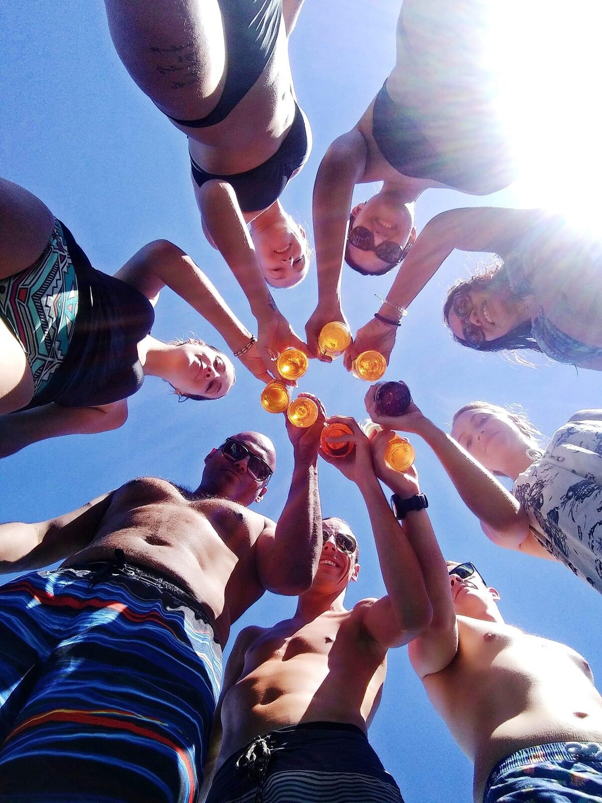 Group raising their drinks together in a toast, seen from below