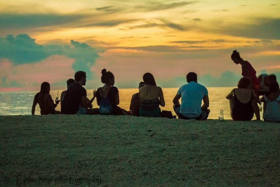 Group watching the sunset from a grassy headland