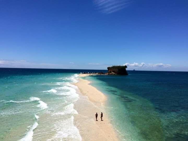 Aerial view of two people on a long, empty sandbar
