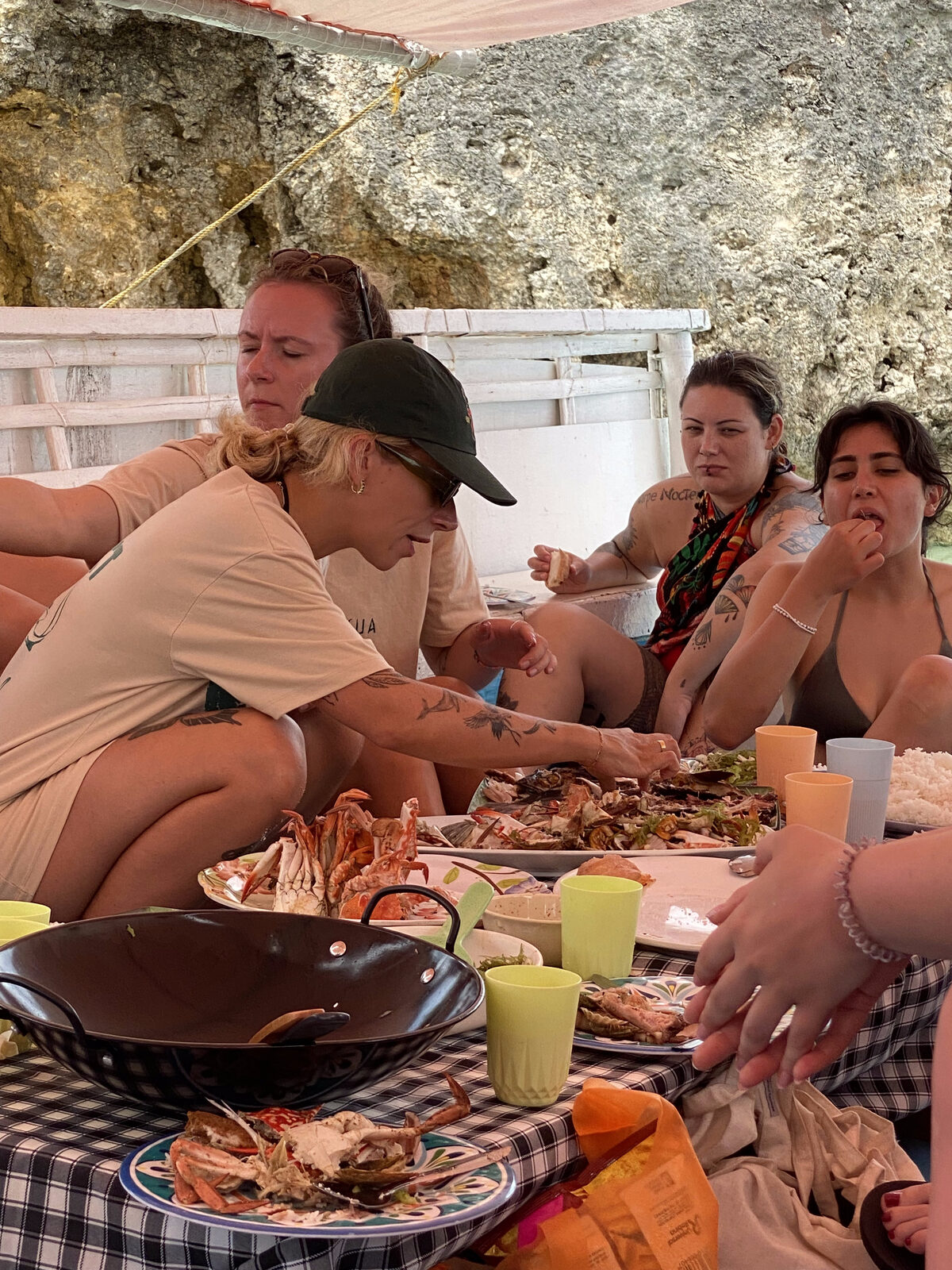 Guests sharing a fresh seafood BBQ of crab and grilled fish aboard the boat