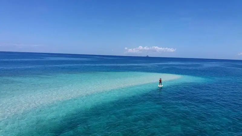 A turquoise sandbar tapering into deep blue water at Carnaza