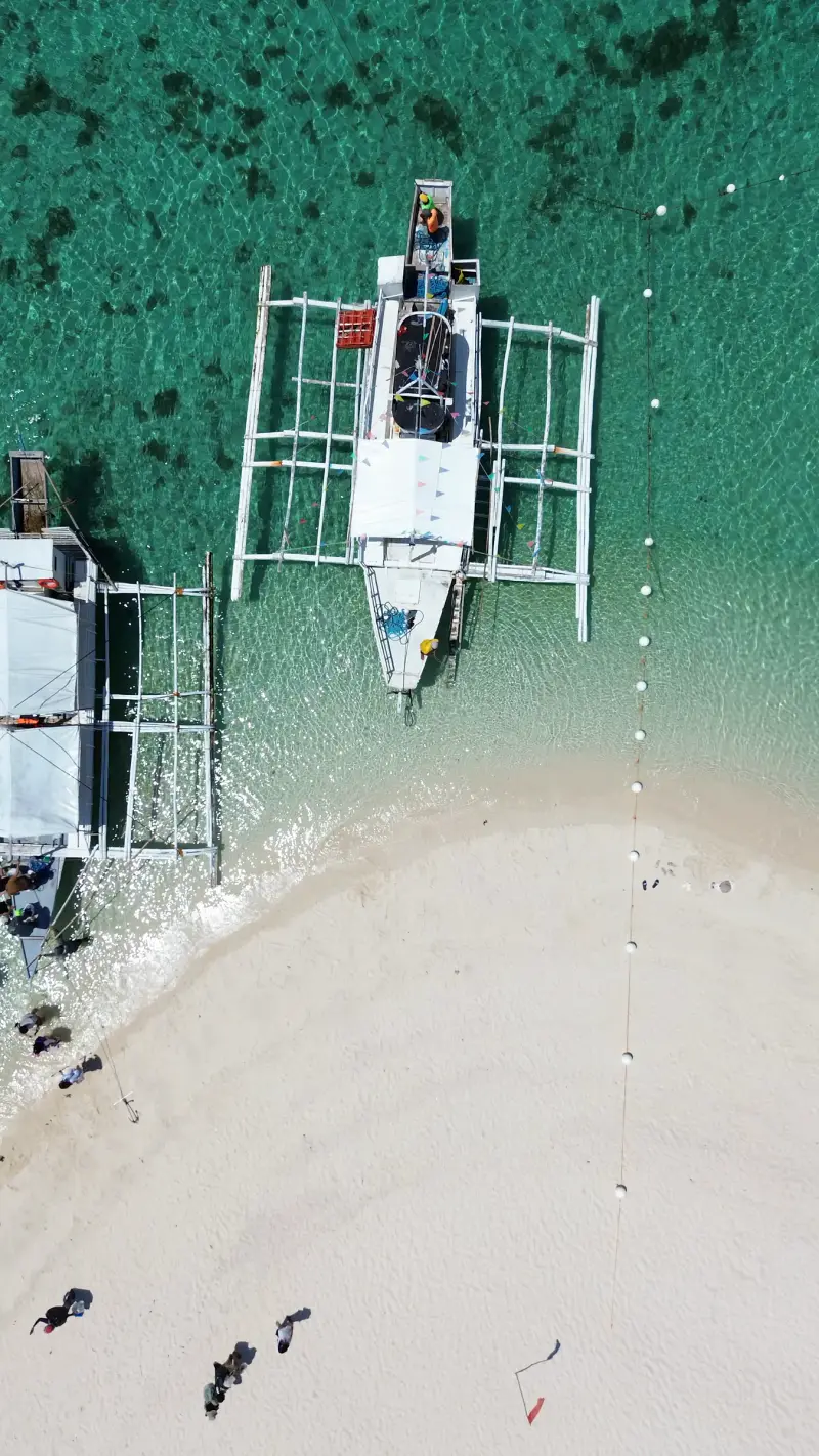 Drone view looking down on outrigger boats moored at the tip of Virgin Island's sandbar